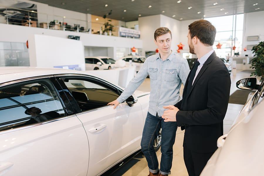 Man preparing to used new car in auto dealership.